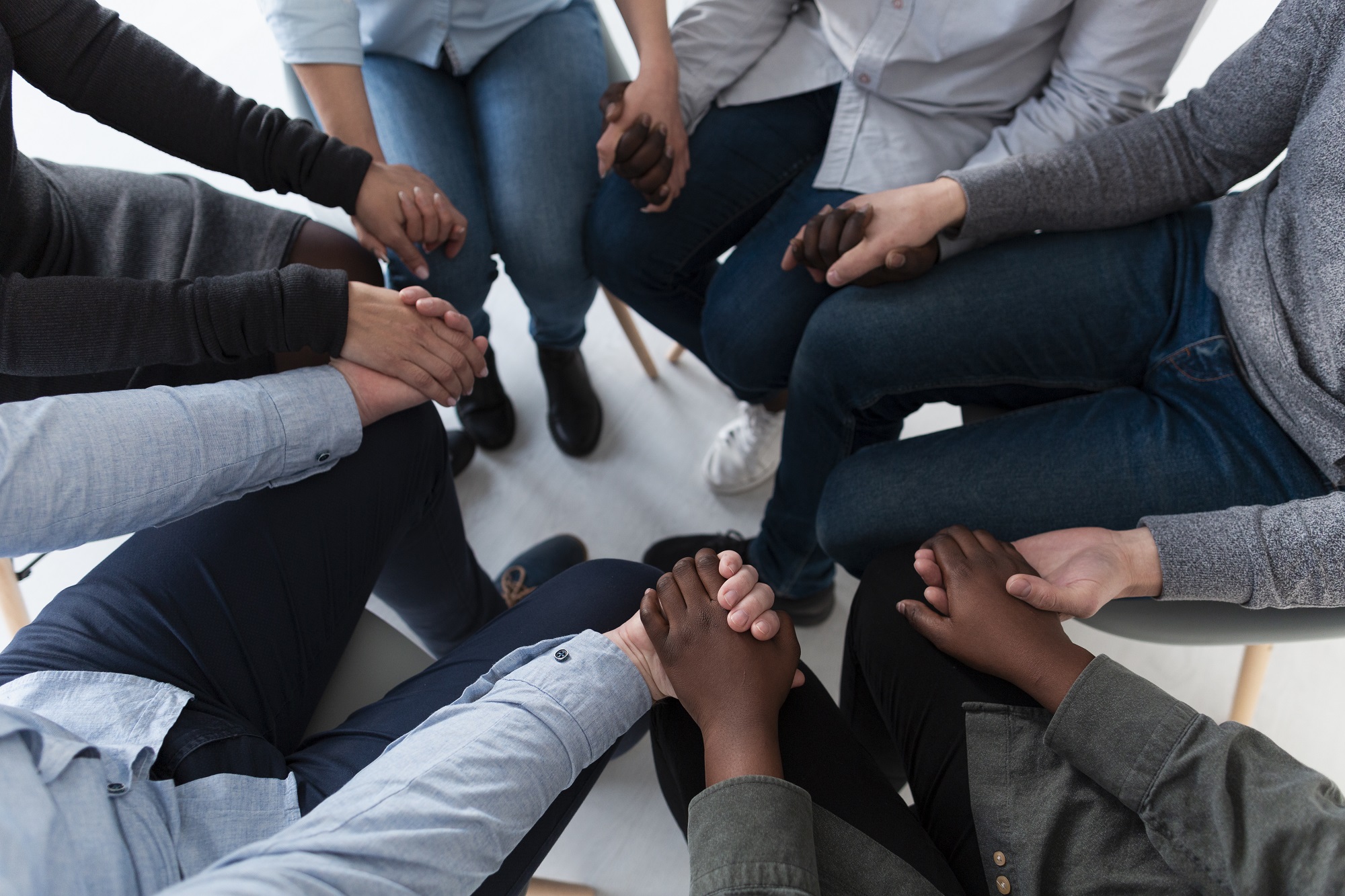 A group holding hands together in prayer